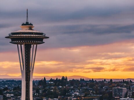 Seattle space needle in foreground with orange purple sunset in background